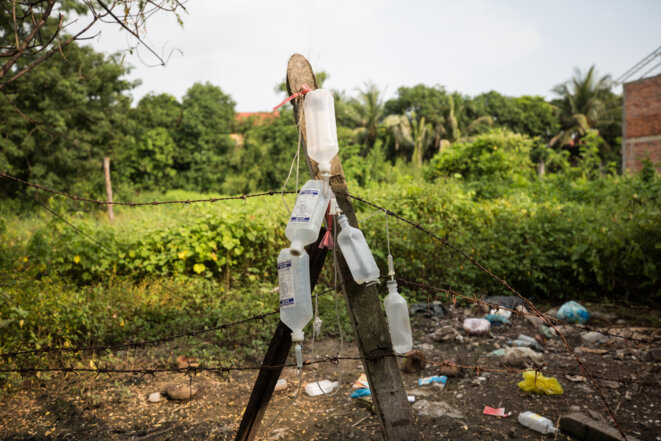 À l’arrière de la maison de la famille Piseth, les bouteilles de solutions pour perfusion intraveineuse qui ont servi pendant cette saison aux membres de la famille infectés par la dengue à s'auto-soigner. © Luke Duggleby À l’arrière de la maison de la famille Piseth, les bouteilles de solutions pour perfusion intraveineuse qui ont servi pendant cette saison aux membres de la famille infectés par la dengue à s'auto-soigner. © Luke Duggleby
