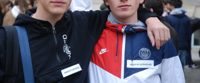 Deux jeunes lycéens posant avec l'étiquette "made by Ouïghours" Deux jeunes lycéens posant avec l'étiquette "made by Ouïghours"