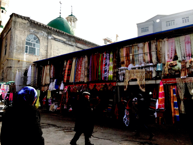 Un marché de tissus à Urumqi avec une mosquée en arrière-plan, où les femmes ouïghoures sont à l'aise pour se couvrir la tête. Un marché de tissus à Urumqi avec une mosquée en arrière-plan, où les femmes ouïghoures sont à l'aise pour se couvrir la tête.