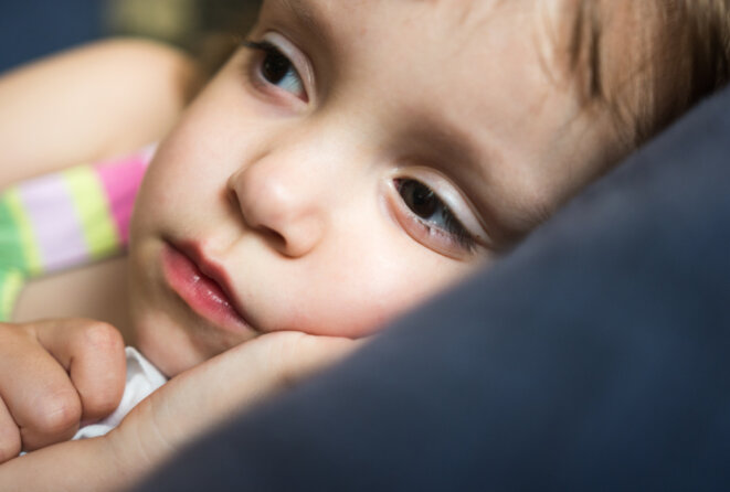Une petite fille allongée et éveillée © Marizza / iStock Une petite fille allongée et éveillée © Marizza / iStock