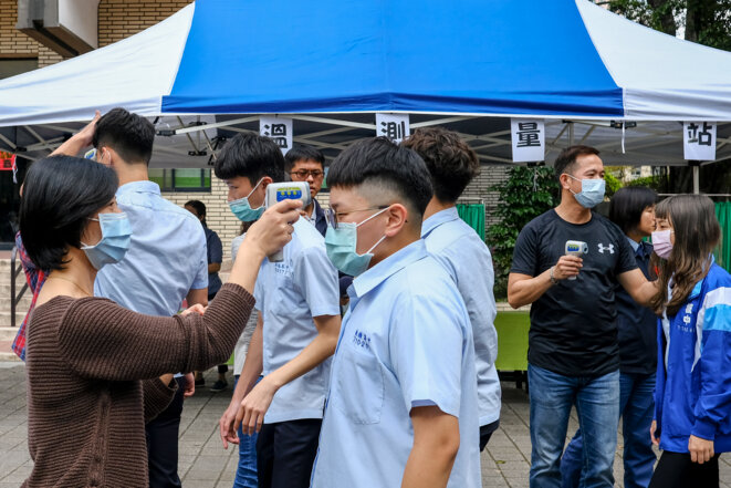 Prise de température et distribution de masques dans un lycée de Banqiao à New Taipei. © Yen-Ting Lin