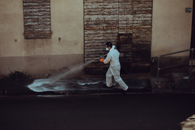 Un homme désinfecte une rue de Marseille contre la propagation du SARS-CoV-2 (Theo Giacometti/Hans Lucas via AFP).