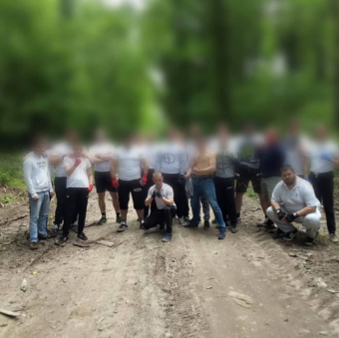 Les Mes Os et au moins trois membres des Zouaves avant un free fight. À noter la croix gammée ainsi que la croix celtique visibles sur les T-shirts de deux participants. Les Mes Os et au moins trois membres des Zouaves avant un free fight. À noter la croix gammée ainsi que la croix celtique visibles sur les T-shirts de deux participants.