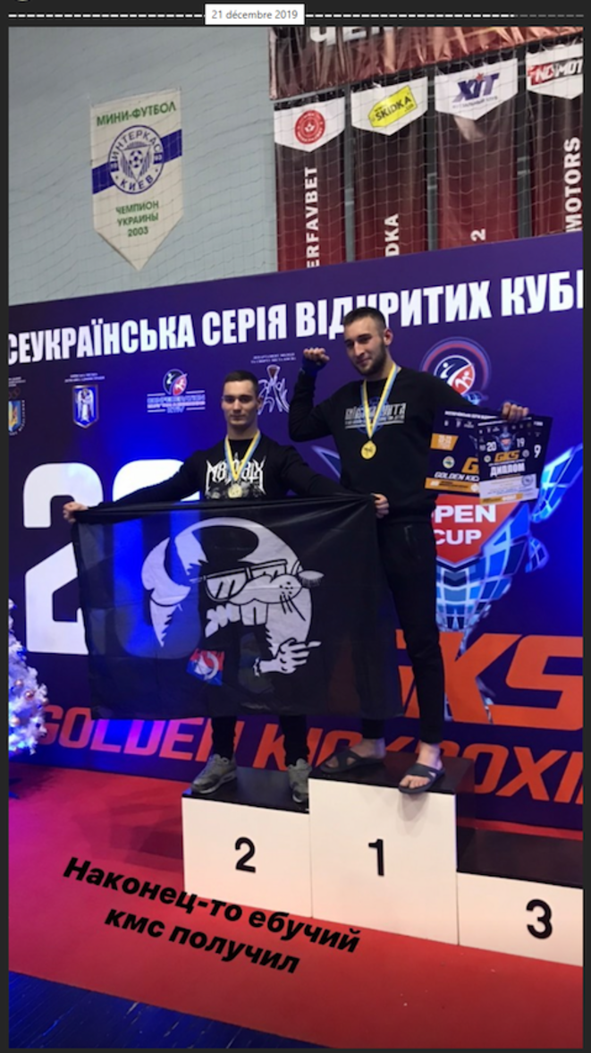 Marc de Cacqueray (à gauche) brandissant un drapeau du GUD Paris, lors d'un championnat de kick-boxing en Ukraine, le 21 décembre 2019. Marc de Cacqueray (à gauche) brandissant un drapeau du GUD Paris, lors d'un championnat de kick-boxing en Ukraine, le 21 décembre 2019.