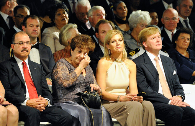 Emily de Jongh Elhage, la dernière Première ministre des Antilles néerlandaises, réagit émotionnellement lors de la cérémonie entourant la dissolution de l’archipel le 10.10.2010. La princesse Máxima et le prince Willem-Alexander (Roi des Pays-Bas depuis le 30.04.2013) sont assis à côté d’elle. Image ANP. Emily de Jongh Elhage, la dernière Première ministre des Antilles néerlandaises, réagit émotionnellement lors de la cérémonie entourant la dissolution de l’archipel le 10.10.2010. La princesse Máxima et le prince Willem-Alexander (Roi des Pays-Bas depuis le 30.04.2013) sont assis à côté d’elle. Image ANP.