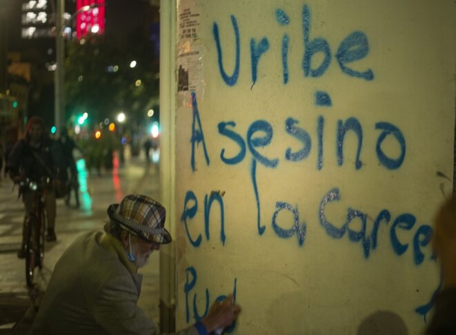 Un opposant à Alvaro Uribe écrit sur un mur de Bogota le 4 août 2020 : « Uribe assassin, en prison… » © Daniel Garzon Herazo/NurPhoto/AFP Un opposant à Alvaro Uribe écrit sur un mur de Bogota le 4 août 2020 : « Uribe assassin, en prison… » © Daniel Garzon Herazo/NurPhoto/AFP