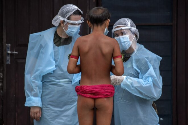 Des membres d'une équipe médicale de l'armée brésilienne avec un membre de l'ethnie yanomani le 1er juillet 2020 à Surucucu, dans l'État de Roraima. © Nelson Almeida/AFP Des membres d'une équipe médicale de l'armée brésilienne avec un membre de l'ethnie yanomani le 1er juillet 2020 à Surucucu, dans l'État de Roraima. © Nelson Almeida/AFP