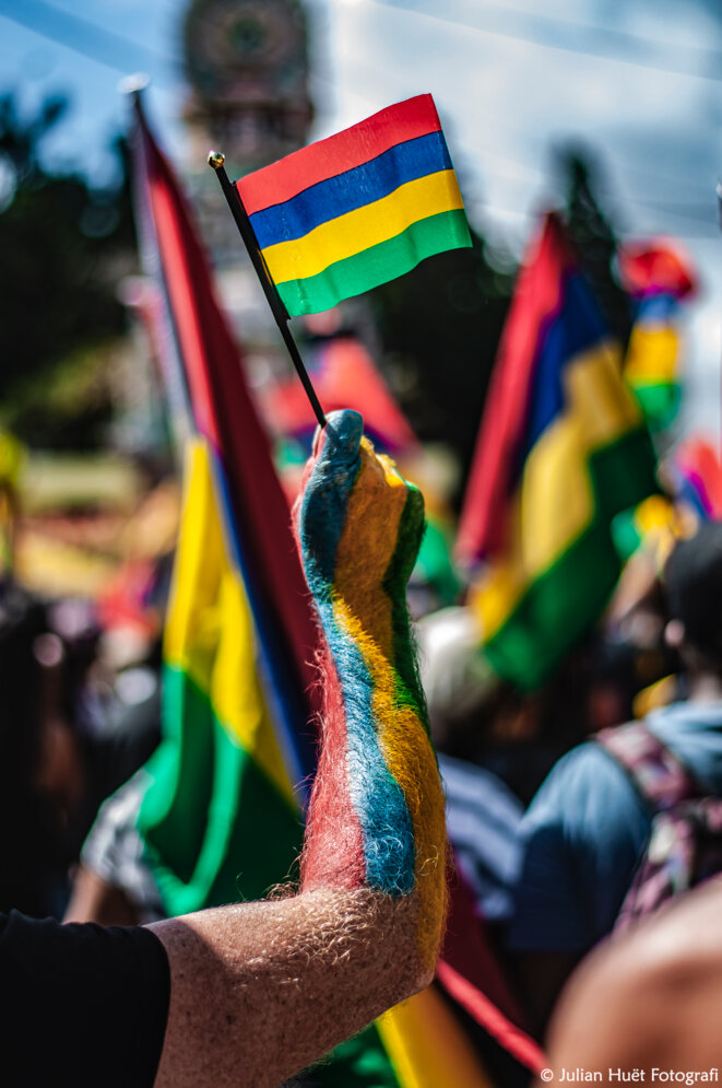 Le drapeau mauricien, fièrement brandi par les manifestants qui réclament un changement profond dans le pays. © Julian Huët Fotografi Le drapeau mauricien, fièrement brandi par les manifestants qui réclament un changement profond dans le pays. © Julian Huët Fotografi