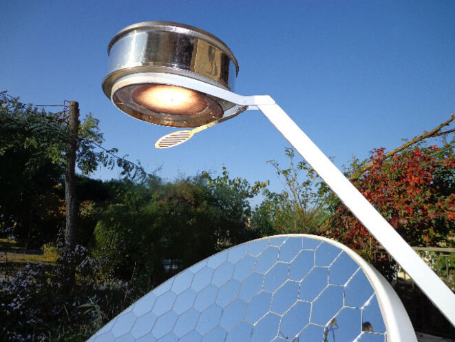 Une parabole solaire produit de la chaleur en concentrant les rayons du soleil sur un récipient. Une parabole solaire produit de la chaleur en concentrant les rayons du soleil sur un récipient.