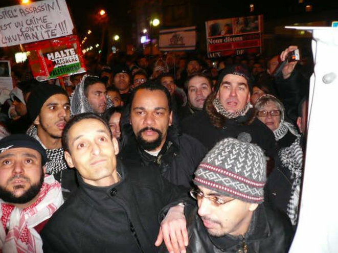 Dieudonné (au centre), Frédéric Chatillon (à droite avec le bonnet), et derrière lui Ginette Skandrani (avec lunettes et bonnet) et Axel Loustau. © Archives du site antifasciste RefleXes Dieudonné (au centre), Frédéric Chatillon (à droite avec le bonnet), et derrière lui Ginette Skandrani (avec lunettes et bonnet) et Axel Loustau. © Archives du site antifasciste RefleXes