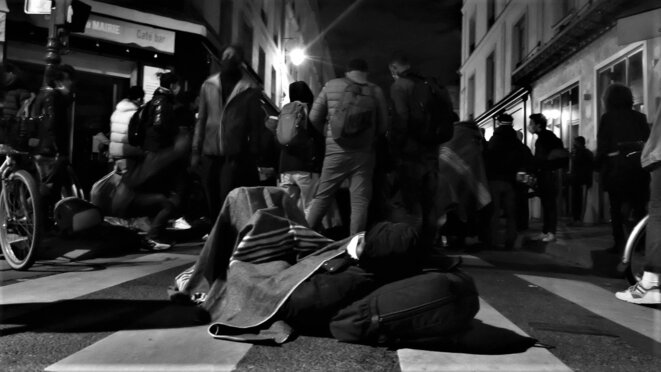 Un homme exilé se repose lors de l'attente dans la rue des Archives © Emile Rabreau Un homme exilé se repose lors de l'attente dans la rue des Archives © Emile Rabreau
