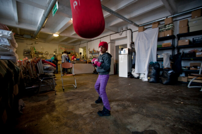 Un enfant arrive et le jour meme joue à boxer sur un sac de frappe © Durand Thibaut Un enfant arrive et le jour meme joue à boxer sur un sac de frappe © Durand Thibaut