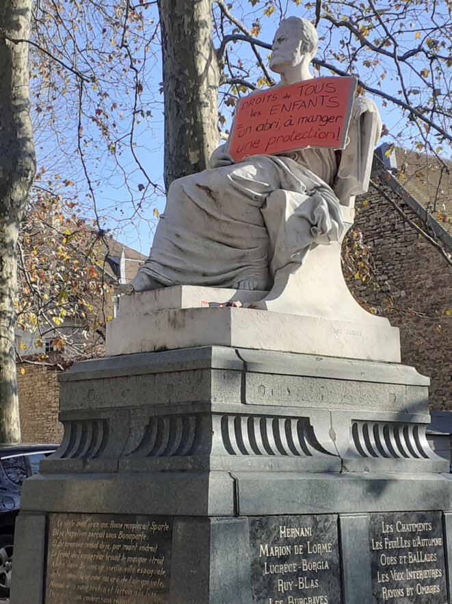 Statue de Victor Hugo, place Granvelle à Besançon : "droit de tous les enfants : un abri, à manger, une protection" [Photo sur mur Facebook de Solmiré]