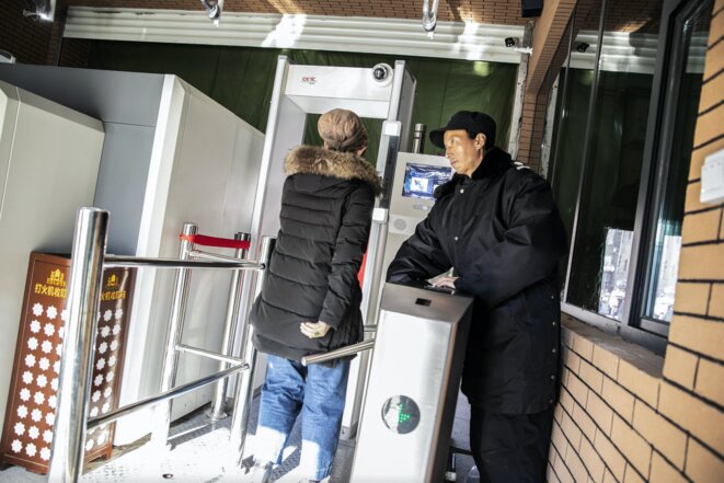 Un agent de sécurité observe le passage d'une femme à un point de contrôle, équipé d'un détecteur de métaux et d'une technologie de reconnaissance faciale, pour entrer dans le bazar principal d'Ürümqi, dans le Xinjiang, le 6 novembre 2018. Photo: Bloomberg via Getty Images Un agent de sécurité observe le passage d'une femme à un point de contrôle, équipé d'un détecteur de métaux et d'une technologie de reconnaissance faciale, pour entrer dans le bazar principal d'Ürümqi, dans le Xinjiang, le 6 novembre 2018. Photo: Bloomberg via Getty Images