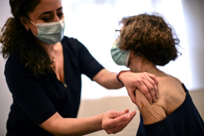 Une médecin généraliste administre une première dose du vaccin AstraZeneca, le 25 février à Paris. © CHRISTOPHE ARCHAMBAULT / AFP.