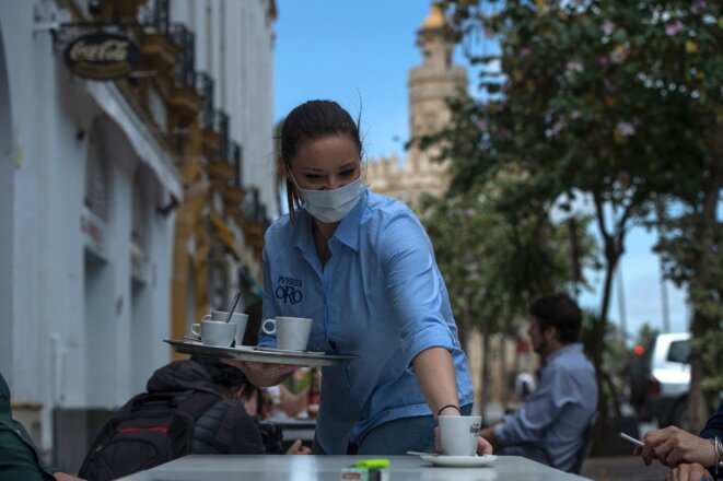 Une serveuse, le 11 mai 2020, à Séville. Le secteur de l'hôtellerie et de la restauration pourrait s'avérer l'un des plus rétifs à la semaine des quatre jours. © AFP / Cristina Quicler Une serveuse, le 11 mai 2020, à Séville. Le secteur de l'hôtellerie et de la restauration pourrait s'avérer l'un des plus rétifs à la semaine des quatre jours. © AFP / Cristina Quicler