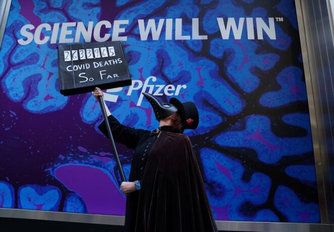 Devant le siège de Pfizer à New York le 11 mars 2021, des manifestants enjoignent Joe Biden et l’industrie pharmaceutique à “libérer” les vaccins anti-Covid. © Timothy A. Clary / AFP Devant le siège de Pfizer à New York le 11 mars 2021, des manifestants enjoignent Joe Biden et l’industrie pharmaceutique à “libérer” les vaccins anti-Covid. © Timothy A. Clary / AFP