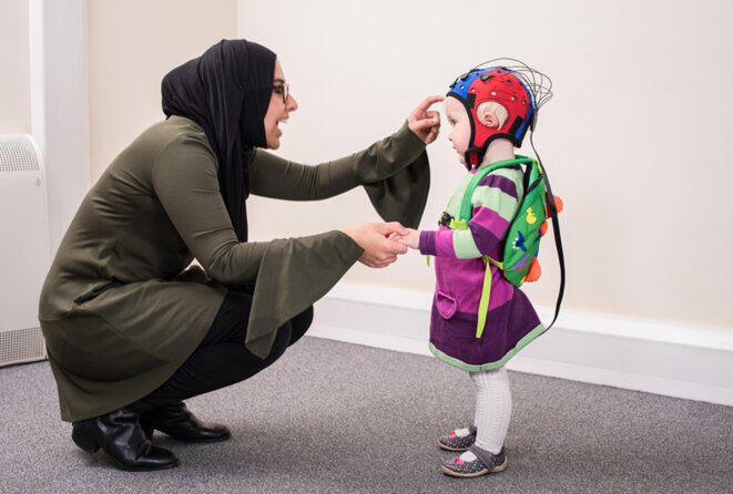 Une femme parle à son enfant dans un casque EEG © Avec l'aimable autorisation d'Emily Jones Une femme parle à son enfant dans un casque EEG © Avec l'aimable autorisation d'Emily Jones