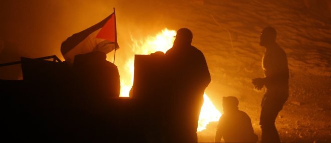 Des Palestiniens et leur drapeau lors d’un rassemblement anti-israélien au checkpoint de Qalandiya, le 11 mai 2021. ABBAS MOMANI / AFP Des Palestiniens et leur drapeau lors d’un rassemblement anti-israélien au checkpoint de Qalandiya, le 11 mai 2021. ABBAS MOMANI / AFP