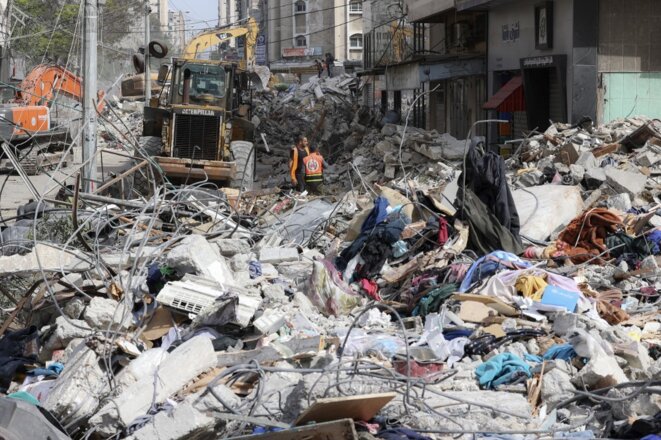 Un engin déblaie les débris d'une attaque israélienne dans le quartier résidentiel de Rimal à Gaza City, le 16 mai 2021 © Mahmud Hams / AFP