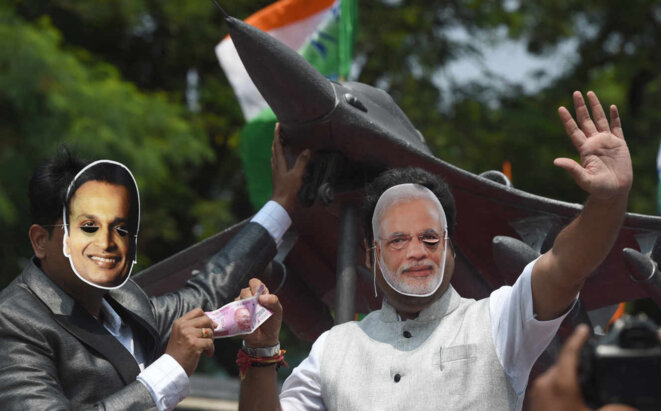 Des manifestants portent des masques du premier ministre indien Modi (droite) et d’Anil Ambani, devant la réplique d’un Rafale, à Bombay, en 2018. © Indranil Mukerjee / AFP Des manifestants portent des masques du premier ministre indien Modi (droite) et d’Anil Ambani, devant la réplique d’un Rafale, à Bombay, en 2018. © Indranil Mukerjee / AFP