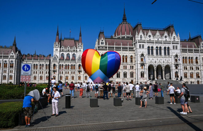 Des activistes font voler un ballon arc-en-ciel dans le but de protester contre l'adoption d'une nouvelle loi discriminatoire devant le Parlement hongrois à Budapest, le 8 juillet 2021 - Attila Kisbenedek / AFP / Getty Images Des activistes font voler un ballon arc-en-ciel dans le but de protester contre l'adoption d'une nouvelle loi discriminatoire devant le Parlement hongrois à Budapest, le 8 juillet 2021 - Attila Kisbenedek / AFP / Getty Images