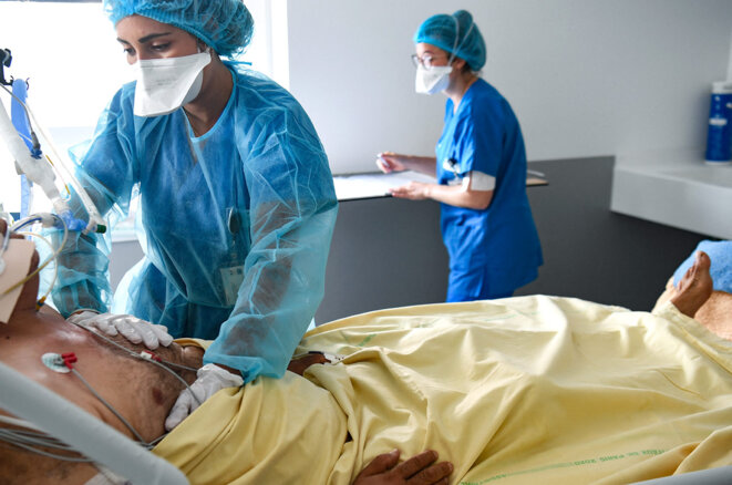 Des membres du personnel médical soignent un patient Covid-19 sous assistance respiratoire, dans le service de réanimation de l'hôpital Henri Mondor à Créteil, le 22 juillet 2021. © Photo Alain Jocard / AFP