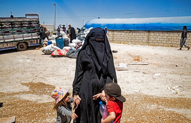 Une femme avec ses enfants, dans le camp d'Al-Hol, qui abrite des proches de combattants du groupe État islamique, dans le nord-est de la Syrie, en mai 2021. © Photo Delil Souleiman / AFP