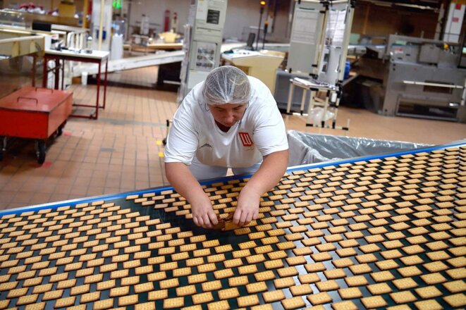 Une employée sur la ligne de production des "Petit Beurre" de la biscuiterie LU à La Haye-Fouassière, près de Nantes, en 2018. © Photo Loïc Venance / AFP Une employée sur la ligne de production des "Petit Beurre" de la biscuiterie LU à La Haye-Fouassière, près de Nantes, en 2018. © Photo Loïc Venance / AFP
