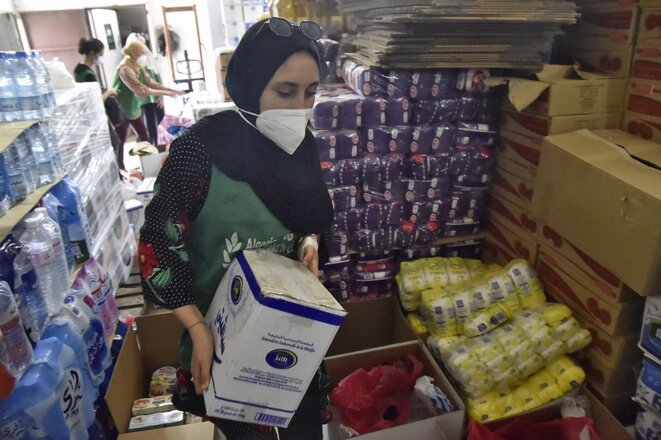 Des volontaires d’une ONG préparent des colis pour les victimes des incendies en Kabylie. © Ryad Kramdi/AFP