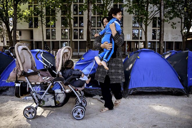 Une femme afghane avec son enfant devant un camp de fortune mis en place par des bénévoles de l'association Utopia 56 le long du bassin de la Villette, à Paris, le 27 mai 2020. © Photo Christophe Archambault / AFP