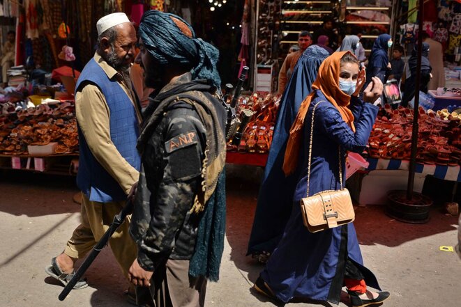 Un combattant taliban croise des femmes Afghanes dans le marché Mandawi à Kaboul, le 1er septembre 2021. © Photo Hoshang Hashimi / AFP Un combattant taliban croise des femmes Afghanes dans le marché Mandawi à Kaboul, le 1er septembre 2021. © Photo Hoshang Hashimi / AFP