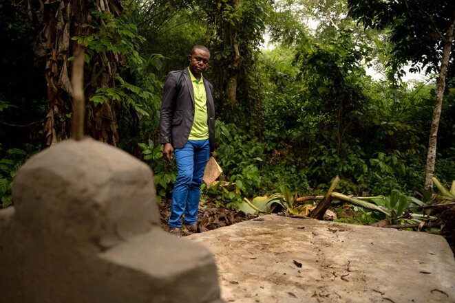 Eddy se recueille sur la tombe de son frère, Blaise Mokwe, tué par des membres de la sécurité de gardiennage de la société Feronia, dans le village de Lokutu (RDC), le 18 juillet 2021. © Photo Anthony Fouchard / Disclose