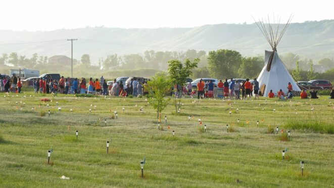 Un hommage est rendu sur le site de la détection de 751 tombes anonymes, marquées par des drapeaux et des lampes, près d'un ancien pensionnat catholique pour autochtones à Marieval (Canada), le 26 juin 2021 [site de francetvinfo, photo Mark Taylor/AP/SIPA) Un hommage est rendu sur le site de la détection de 751 tombes anonymes, marquées par des drapeaux et des lampes, près d'un ancien pensionnat catholique pour autochtones à Marieval (Canada), le 26 juin 2021 [site de francetvinfo, photo Mark Taylor/AP/SIPA)