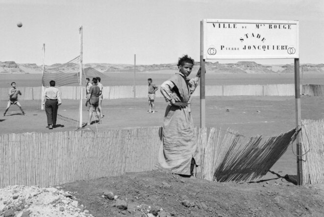 Des techniciens français de la Compagnie de recherche et d'exploitation pétrolière au Sahara (CREPS) jouent au volley-ball sur la base pétrolière d'Edjeleh Maison-Rouge, dans le désert algérien. Mars 1957. © AFP