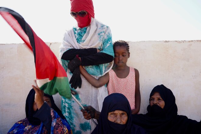 Des femmes brandissent dans le camp de réfugiés de Boujdour le drapeau sahraoui à l'occasion de la 45e fête de l'unité nationale (Tindouf, Algérie, octobre 2021). © Arnaud Marin Des femmes brandissent dans le camp de réfugiés de Boujdour le drapeau sahraoui à l'occasion de la 45e fête de l'unité nationale (Tindouf, Algérie, octobre 2021). © Arnaud Marin