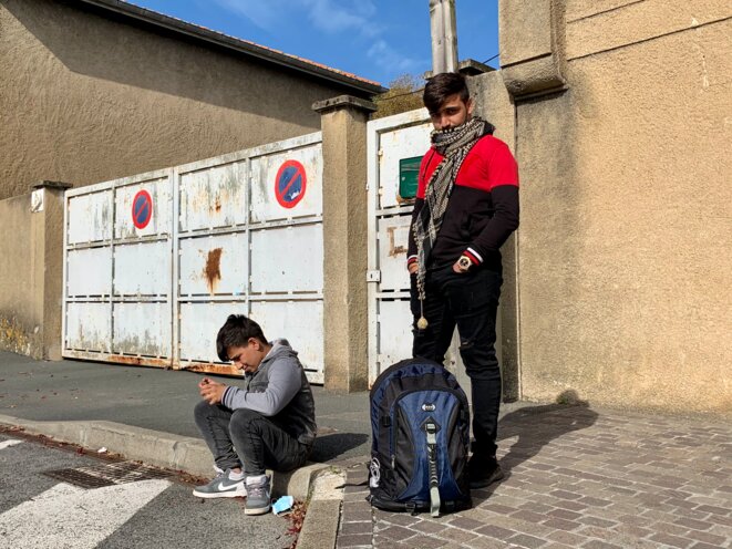 M., 20 ans, et son petit frère, attendent impatiemment le bus qui leur permettra de rejoindre leur mère réfugiée en France. © NB