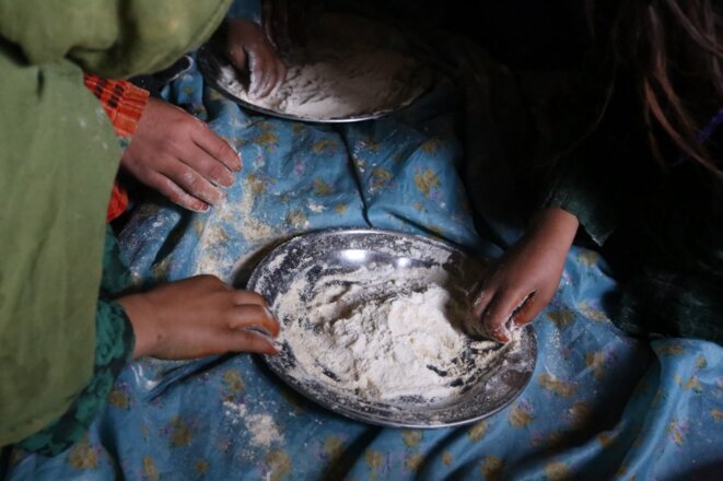 Herat, 11 janvier 2022. Des enfants se nourrissent de farine. © Bilal Guler / Anadolu Agency via AFP