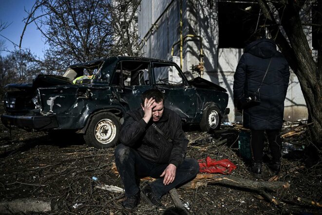 Un homme est assis devant son immeuble détruit après les bombardements sur la ville de Chuguiv, dans l'est de l'Ukraine, le 24 février 2022. © Photo Aris Messinis / AFP