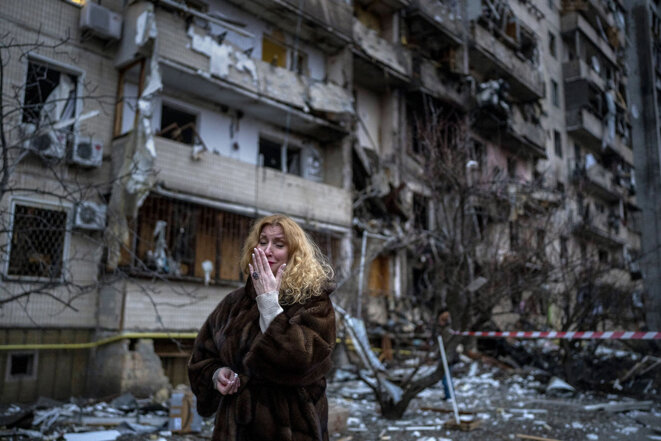 Une habitante de Kiev en pleurs à côté de son immeuble détruit par une attaque à la roquette, le 25 février 2022. © Photo Emilio Morenatti / AP / Sipa