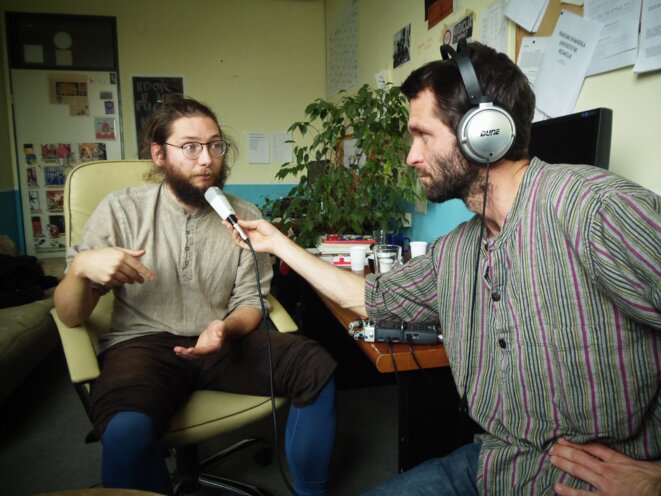 Théo Fortunato tend le micro à Arne, dans les locaux de Radio Študent 89,3 MHz à Ljubljana, en Slovénie. 2020. Photo: Suzy Chatton
