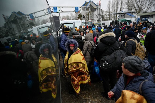 Des réfugié·es ukrainien·nes attendent de monter dans un bus au point de contrôle de la frontière moldo-ukrainienne près de Palanca, le 1er mars 2022. © Photo Nikolay Doychinov / AFP