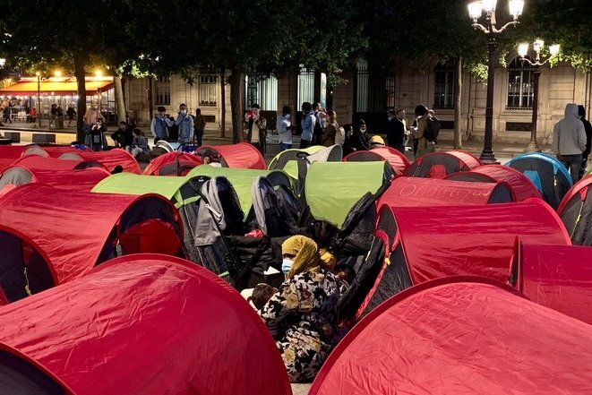 Des exilés en attente d'une solution d'hébergement, installés dans un campement lors d'une action à Paris, en 2021.