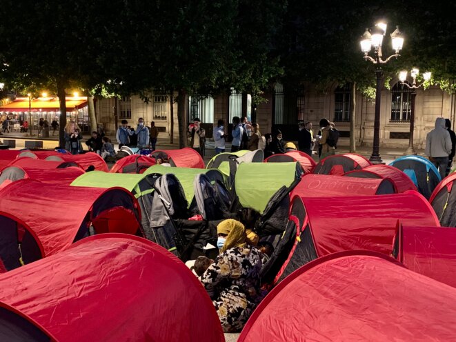 Des exilés en attente d'une solution d'hébergement, installés dans un campement lors d'une action à Paris, en 2021. © Nejma Brahim / Mediapart