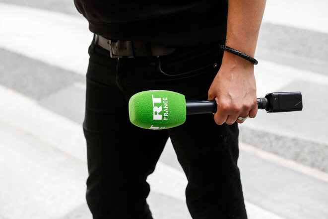 Un micro de RT France dans la main d’un journaliste à Paris en 2020. © Photo Sébastien Calvet / Mediapart