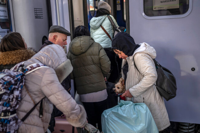 Des réfugiés ukrainiens montent à bord d'un train en route vers Varsovie à la gare de Przemysl, près de la frontière polono-ukrainienne. © Photo Angelos Tzortzinis / AFP