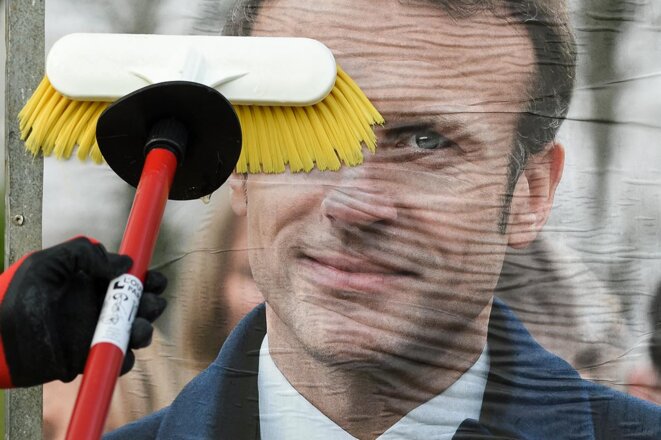 Collage de l'affiche de campagne d’Emmanuel Macron à Saint-Herblain, le 28 mars 2022. © Photo Sébastien Salom-Gomis / AFP