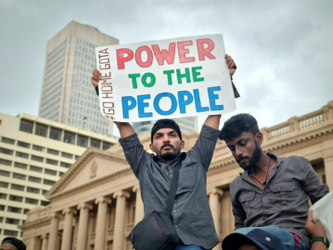 Des manifestants montent sur les grilles du palais présidentiel de Colombo. © Photo Côme Bastin pour Mediapart