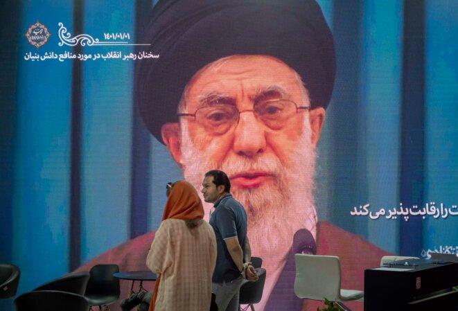 Un couple devant le portrait du guide suprême Ali Khamenei à Téhéran, le 13 mai 2022. © Photo de Morteza Nikoubazl/NurPhoto/AFP