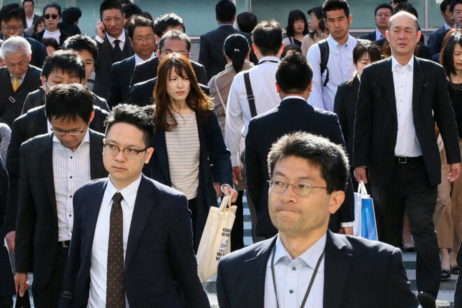 Des employés se dirigent vers leur bureau devant la gare de Hakata, à Fukuoka, au Japon, en mai 2019. © Photo Katsumi Tanaka / Yomiuri Shimbun via AFP